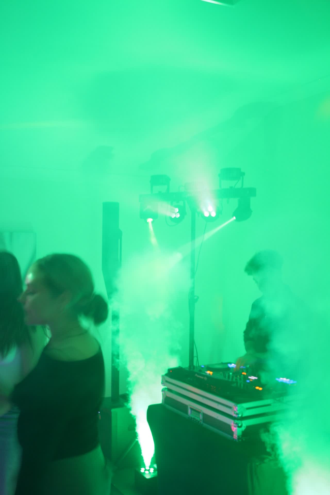 Party lights and vertical smoke machine filling the room with green light