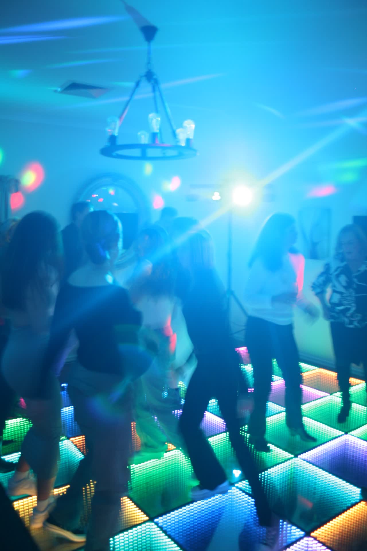 Guests dancing on the colourful LED dance floor at a Perth house party